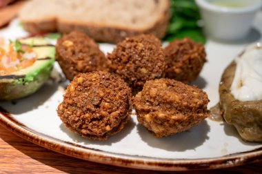 Sağlıklı vejetaryen yemekleri, vejetaryen falafel topları ızgara patlıcan ve ızgara avokado ile servis edilir.