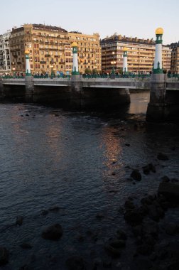 Evening walk along river in central part of Donostia or San Sebastian city, Basque Country, Spain in winter