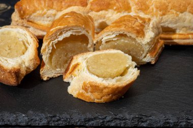 Taze fırında Hollanda baharatlı kurabiyeler, puf böreklerinden, sonbahar renklerinde bademlerle koyu taşlara yakın.