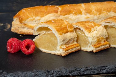 Taze fırında Hollanda baharatlı kurabiyeler, puf böreklerinden, sonbahar renklerinde bademlerle koyu taşlara yakın.