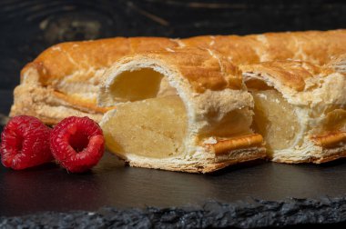 Taze fırında Hollanda baharatlı kurabiyeler, puf böreklerinden, sonbahar renklerinde bademlerle koyu taşlara yakın.