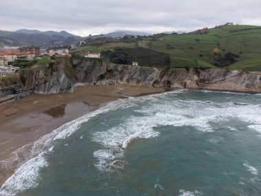 View on sandy beach, rocks and Atlantic ocean in Zumaia touristic ciry, Basque Country, Spain at winter