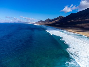 Fuerteventura, Kanarya Adaları 'ndaki sıradağların arkasına gizlenmiş altın kumlu kumlu kumlu plaja ulaşmak zor.