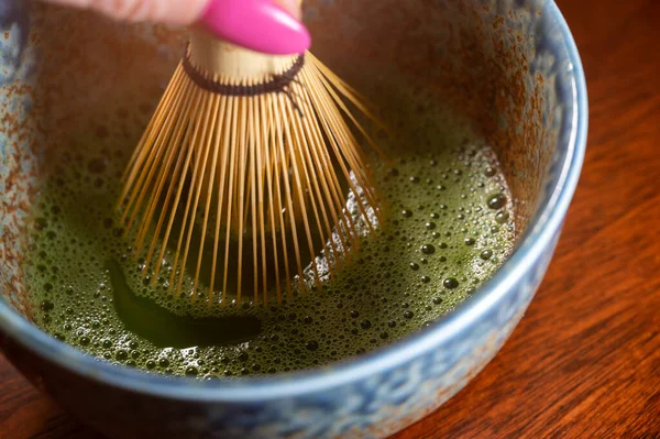 Preparation of green Matcha tea from finely ground powder of specially grown and processed green tea leaves consumed in East Asia and Japan.