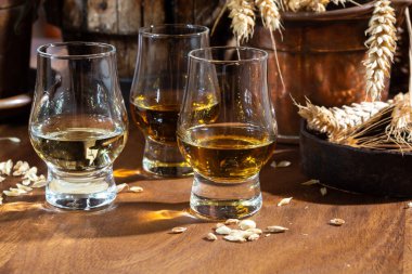 Arpa tanecikli, eski, siyah ahşap masadaki, yıllanmış viski ile küçük bardakları tadıyorum.