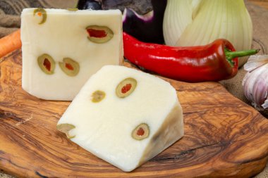 Peynir koleksiyonu, koyun sütünden yapılmış taze İtalyan pecorino peyniri. İçi yeşil zeytinlerle doldurulmuş kırmızı kırmızı paprikayla yakın plan.