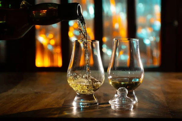 在背景中倒入郁金香状品酒苏格兰威士忌单麦芽或混合威士忌酒吧 — 图库照片