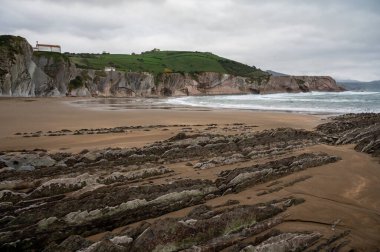 Zumaia 'nın Atlantik kıyısındaki alçak gelgitte, İspanya' nın Bask Bölgesi 'nde dik eğimli sinek jeolojik oluşumuna bakın.