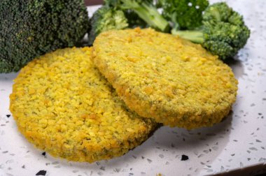 Uncooked fresh vegan and vegetarian burgers made from fresh vegetables and dried legumes and beans, ready to barbecue grill