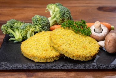 Uncooked fresh vegan and vegetarian burgers made from fresh vegetables and dried legumes and beans, ready to barbecue grill