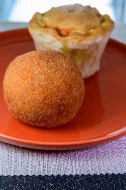 Traditional street food in UK, stuffed fried Scotch eggs with breadcrumbs and baked pie with pork meat close up