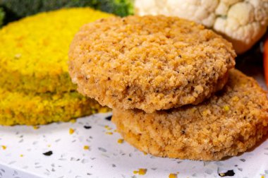 Uncooked fresh vegan and vegetarian burgers made from fresh vegetables and dried legumes and beans, ready to barbecue grill