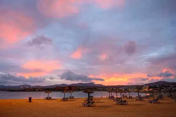 stock image Sandy beach after sunset. Winter sea and sun vacation in Caleta de Fuste touristic village on Fuerteventura, Canary islands, Spain