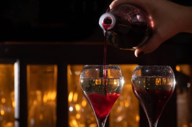 Kir Royal içilen, üzerinde şampanya bulunan kremalı Fransız aperatifi bardakta servis edilen lale kokteyli.