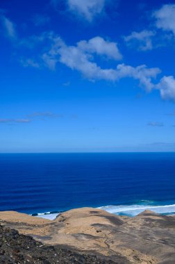Fuerteventura, Kanarya Adaları 'ndaki sıradağların arkasına gizlenmiş altın kumlu, uzun kahve plajına ulaşmak zor.
