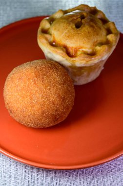 Traditional street food in UK, stuffed fried Scotch eggs with breadcrumbs and baked pie with pork meat close up