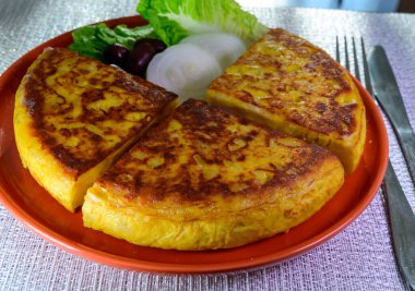 Spanish vegetarian food, portion of homemade tasty potato omelette tortilla de patatas with onion served on terrace in morning sunlights