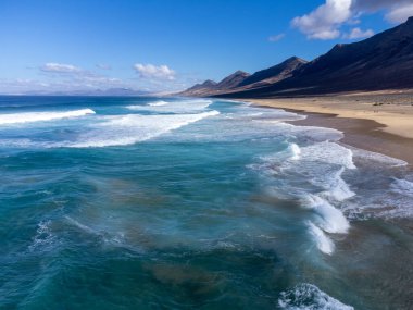 Fuerteventura, Kanarya Adaları 'ndaki sıradağların arkasına gizlenmiş altın kumlu kumlu kumlu plaja ulaşmak zor.