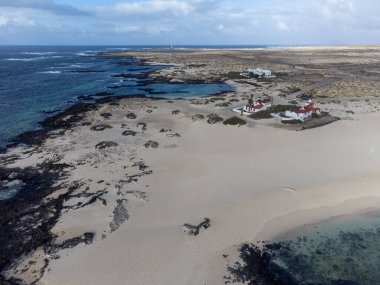 Beyaz kumullarda hava manzarası, La Concha sahilinde mavi okyanus suyu, El Cotillo sörfçüleri köyü, Fuerteventura, Kanarya adaları, İspanya 'da kış