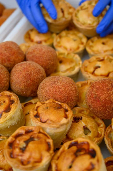 Traditional street food in UK, stuffed fried Scotch eggs with breadcrumbs and baked pie with pork meat close up