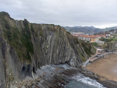 Zumaia 'nın Atlantik kıyısındaki alçak gelgitte, İspanya' nın Bask Bölgesi 'nde dik eğimli sinek jeolojik oluşumuna bakın.