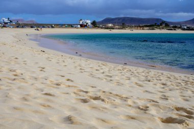 Beyaz kum, mavi su ve fırtınalı bulutlar La Concha sahilinde, El Cotillo sörfçülerinin köyü, Fuerteventura, Kanarya adaları, İspanya