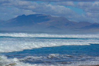 Fuerteventura, Kanarya Adaları 'ndaki sıradağların arkasına gizlenmiş altın kumlu, uzun kahve plajına ulaşmak zor.