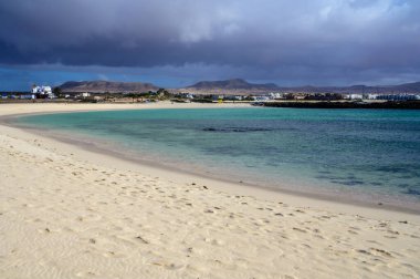 Beyaz kum, mavi su ve fırtınalı bulutlar La Concha sahilinde, El Cotillo sörfçülerinin köyü, Fuerteventura, Kanarya adaları, İspanya