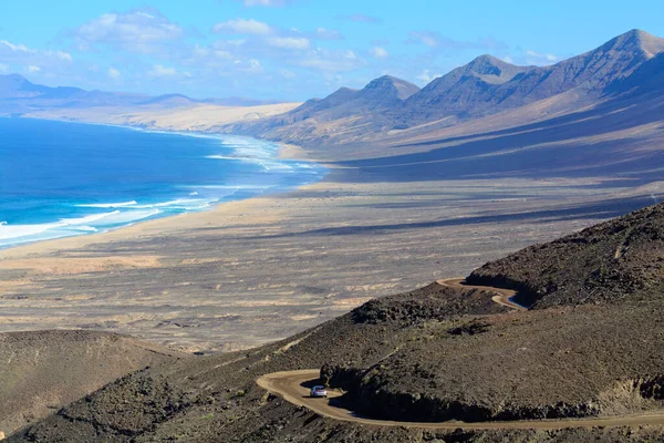 Fuerteventura, Kanarya Adaları 'ndaki sıradağların arkasına gizlenmiş altın kumlu, uzun kahve plajına ulaşmak zor.