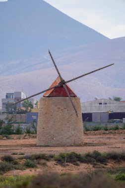 Old traditional Canarian grain wind mill near Antigua village, countryside landscape of Fuerteventura island, Canary islands, Spain