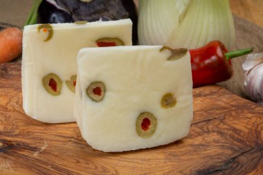 Peynir koleksiyonu, koyun sütünden yapılmış taze İtalyan pecorino peyniri. İçi yeşil zeytinlerle doldurulmuş kırmızı kırmızı paprikayla yakın plan.