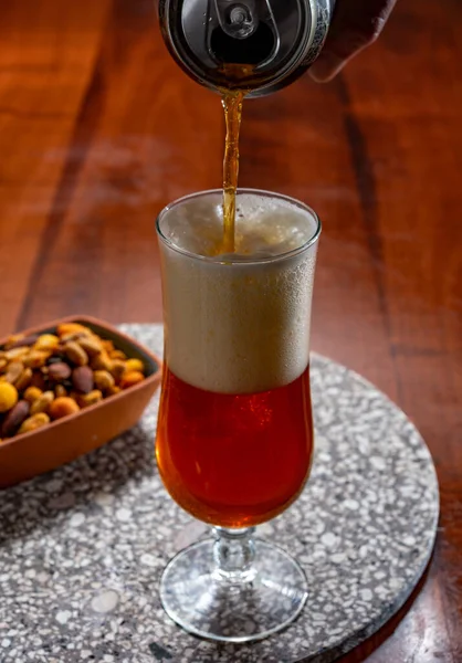 stock image Glass of Belgian light blond beer made in abbey and bowl with party mix nuts, close up