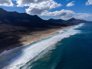 Fuerteventura, Kanarya Adaları 'ndaki sıradağların arkasına gizlenmiş altın kumlu kumlu kumlu plaja ulaşmak zor.