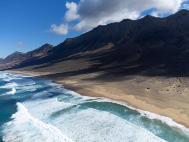 Fuerteventura, Kanarya Adaları 'ndaki sıradağların arkasına gizlenmiş altın kumlu kumlu kumlu plaja ulaşmak zor.