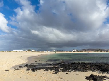 Beyaz kum, mavi su ve fırtınalı bulutlar La Concha sahilinde, El Cotillo sörfçülerinin köyü, Fuerteventura, Kanarya adaları, İspanya