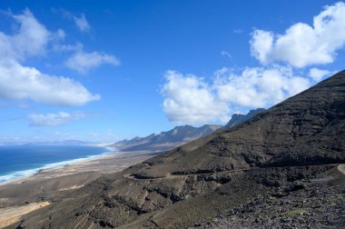 Fuerteventura, Kanarya Adaları 'ndaki sıradağların arkasına gizlenmiş altın kumlu, uzun kahve plajına ulaşmak zor.