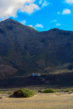 Fuerteventura, Kanarya Adaları 'ndaki sıradağların arkasına gizlenmiş altın kumlu, uzun kahve plajına ulaşmak zor.