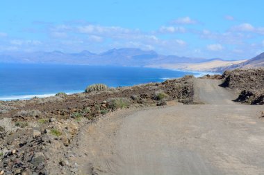 Fuerteventura, Kanarya Adaları 'ndaki sıradağların arkasına gizlenmiş altın kumlu, uzun kahve plajına ulaşmak zor.