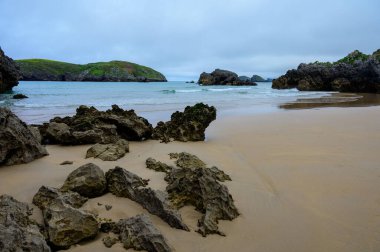 Celorio 'daki Playa de Borizo' daki kayalara bakın. Kuzey İspanya, Asturias 'ın yeşil kıyıları. Beyaz kumlu plajlar, uçurumlar, gizli mağaralar, yeşil tarlalar, ormanlar ve dağlar..