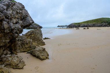 Celorio 'daki Playa de Borizo' daki kayalara bakın. Kuzey İspanya, Asturias 'ın yeşil kıyıları. Beyaz kumlu plajlar, uçurumlar, gizli mağaralar, yeşil tarlalar, ormanlar ve dağlar..
