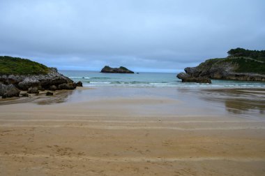 Celorio köyündeki Playa de Palombina Las Camaras 'ın manzarası, Kuzey İspanya, Asturias' ın yeşil kıyıları, kumlu plajları, kayalıkları, gizli mağaraları, yeşil tarlaları, ormanları ve dağları olan.