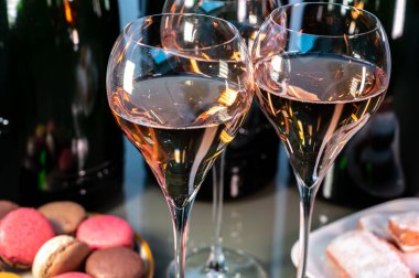 Tasting of rose brut Champagne sparkling wine in cellars of gran cru wine house in Epernay, wine tour in Champagne, France, magnum bottles on background