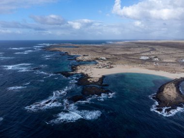 Beyaz kumullarda hava manzarası, La Concha sahilinde mavi okyanus suyu, El Cotillo sörfçüleri köyü, Fuerteventura, Kanarya adaları, İspanya 'da kış