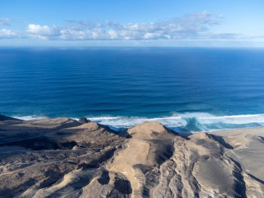 Fuerteventura, Kanarya Adaları 'ndaki sıradağların arkasına gizlenmiş altın kumlu kumlu kumlu plaja ulaşmak zor.