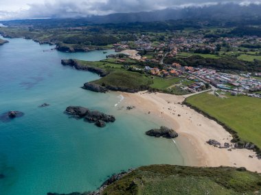 Playa de Palombina, Las Camaras ve Celorio 'daki hava manzarası, Asturias, Kuzey İspanya' nın yeşil kıyıları, beyaz kumlu plajları, kayalıkları, gizli mağaraları, yeşil tarlaları ve dağları olan.