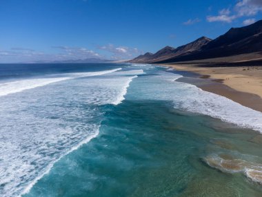 Fuerteventura, Kanarya Adaları 'ndaki sıradağların arkasına gizlenmiş altın kumlu kumlu kumlu plaja ulaşmak zor.