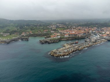 Playa de Toro 'daki hava manzarası ve eski Llanes limanı, Kuzey İspanya, Asturias' ın yeşil kıyıları kumlu plajları, uçurumları, gizli mağaraları, yeşil tarlaları, ormanları ve dağları olan.