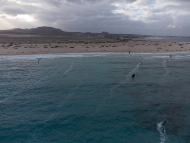 Beyaz kumlu Corallejo kumulları, plaj, okyanus dalgaları ve kışın uçurtma sörfçüleri, Fuerteventura, Kanarya adaları, İspanya