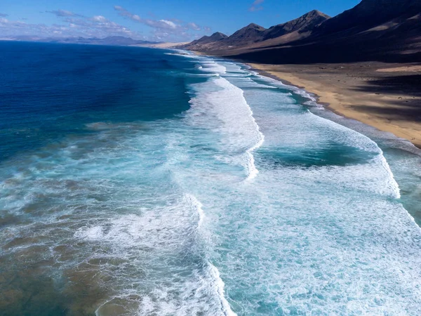 stock image Aerial view on difficult to access golden sandy long Cofete beach hidden behind mountain range on Fuerteventura, Canary islands, Spain