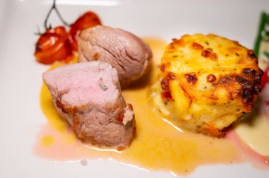 Kızarmış sığır eti ve patates ve krema soslu sebze ile servis edilen domuz eti.